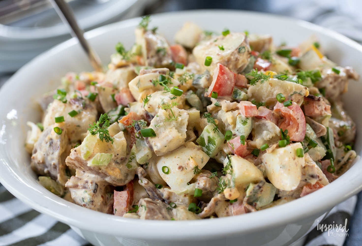 up close photo of potato salad in a white bowl.