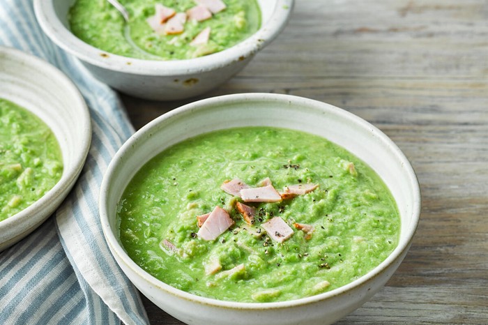 Pea and ham soup Three bowls of pea soup topped with ham slices