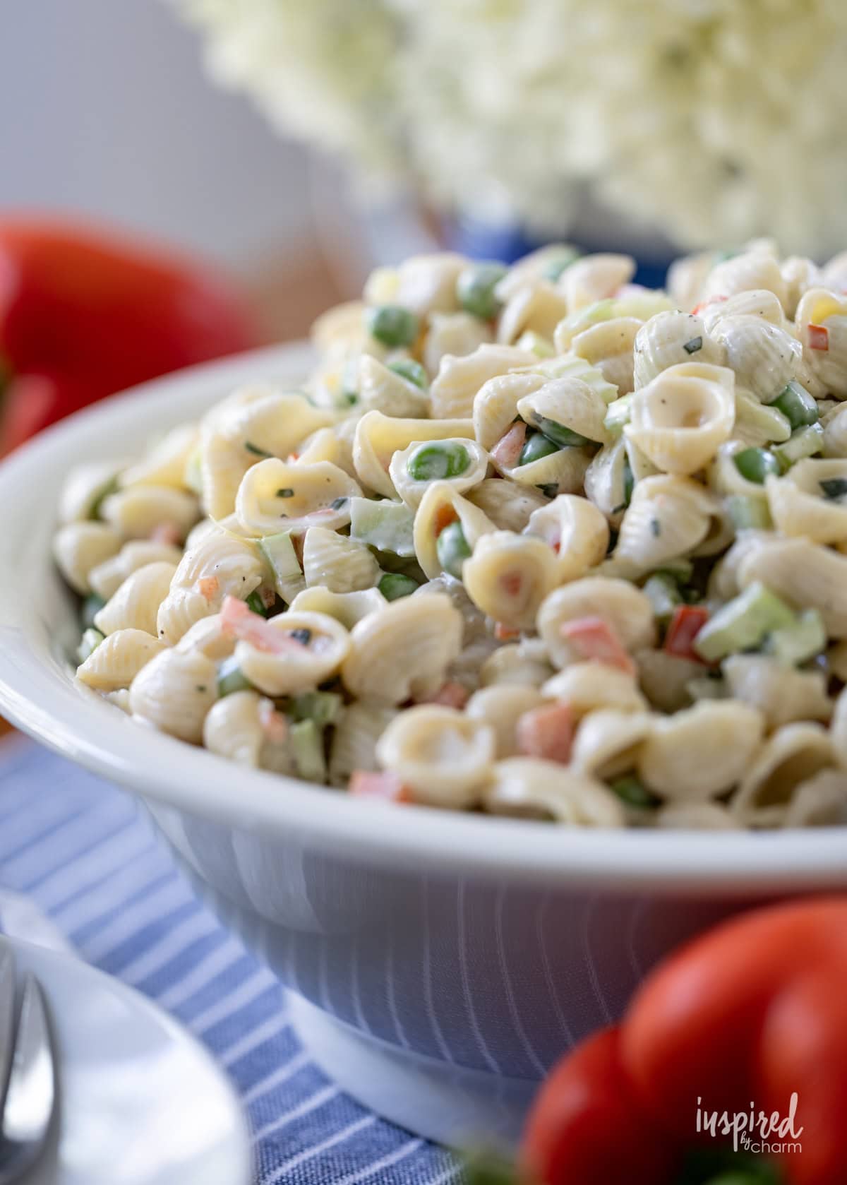 creamy shell macaroni salad with peas in a bowl.